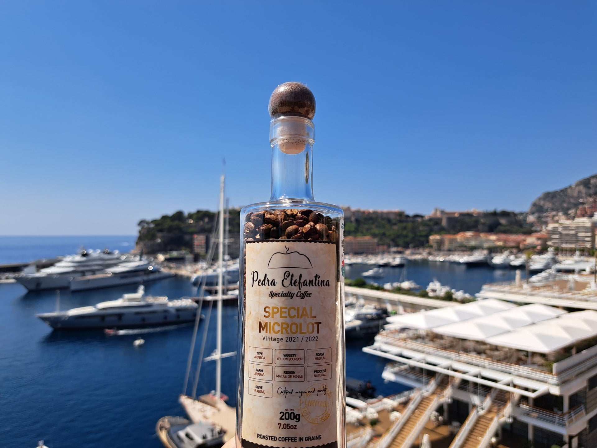 Bottiglia di Caffe Specialty Pedra Elefantina in Edizione Premium davanti alla Marina Port Hercule a Monte-Carlo, Monaco. Acquista i caffe su ArrudaNappi.it